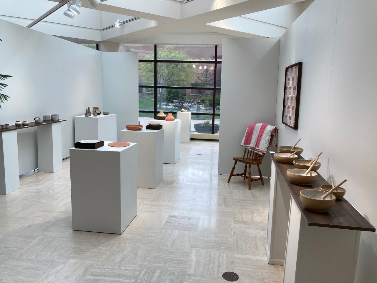 back section of exhibition with kitchen utensels tile quilt and bowls with serving spoons